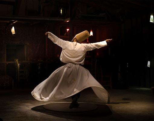 Sufi whirling dervish performing in traditional attire, Istanbul, Turkey.
