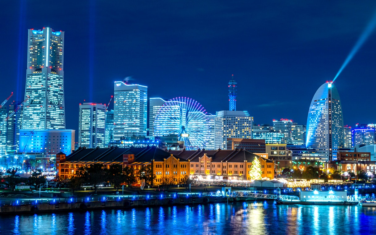 Yokohama waterfront skyline with Ferris wheel and modern buildings at night.