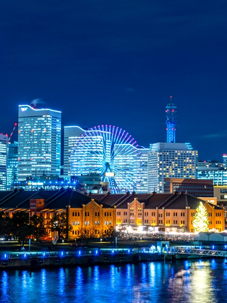 Yokohama waterfront skyline with Ferris wheel and modern buildings at night.