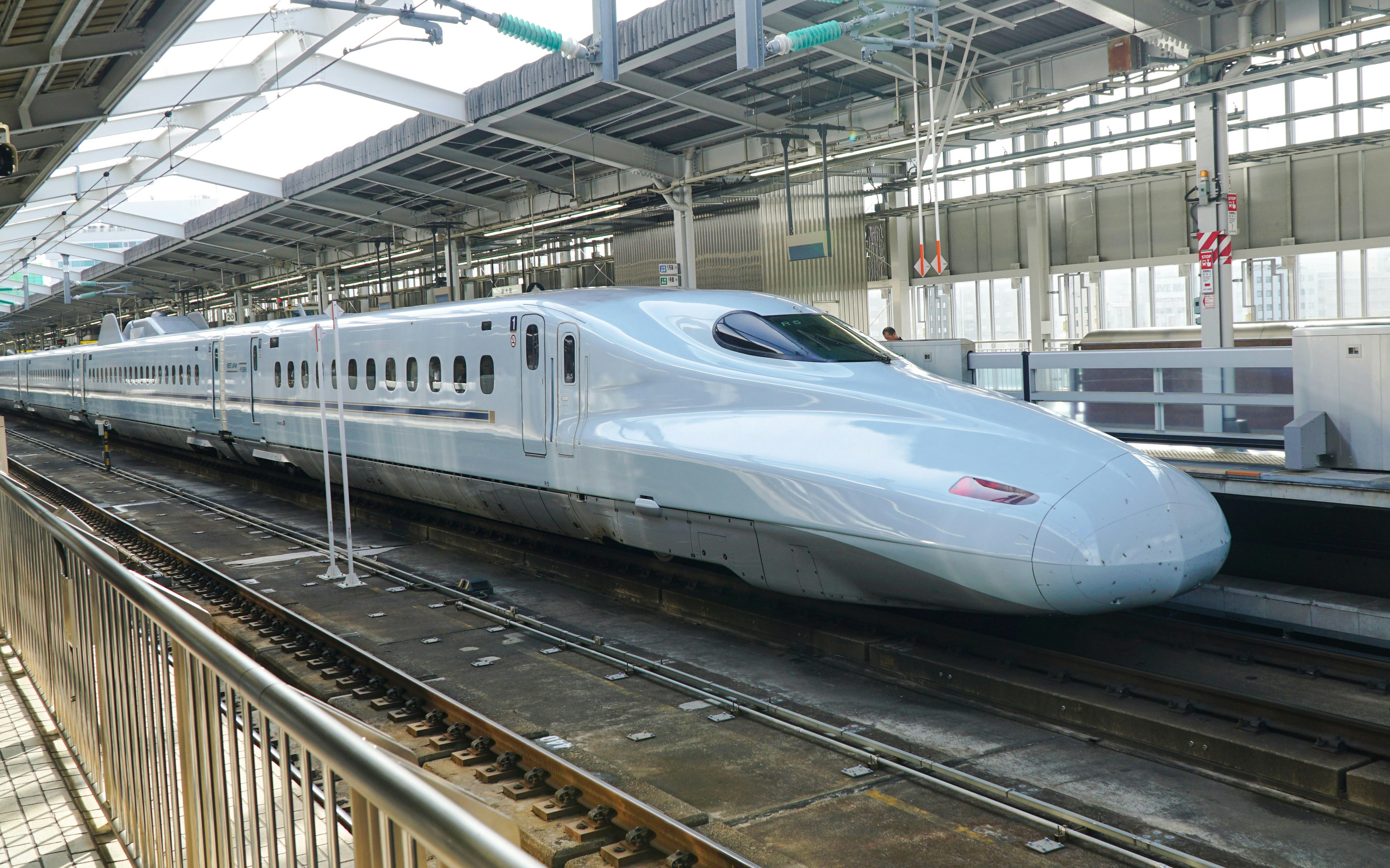 Shinkansen bullet train at a station platform in Japan.