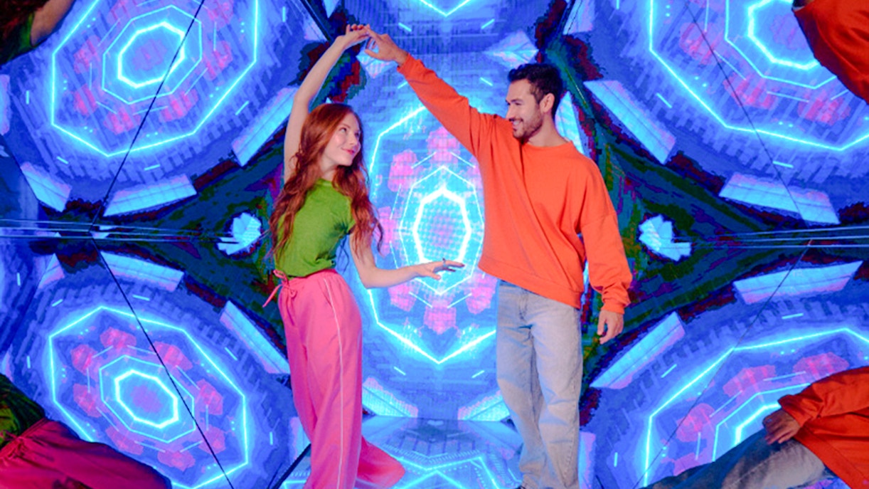 Guests enjoying interactive exhibit at Paradox Museum London with vibrant neon lights.