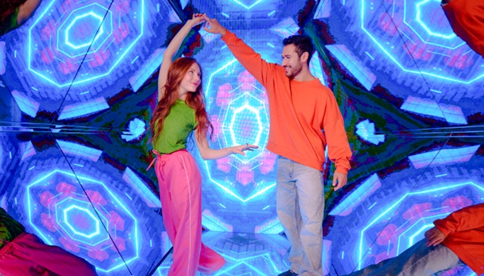 Guests enjoying interactive exhibit at Paradox Museum London with vibrant neon lights.