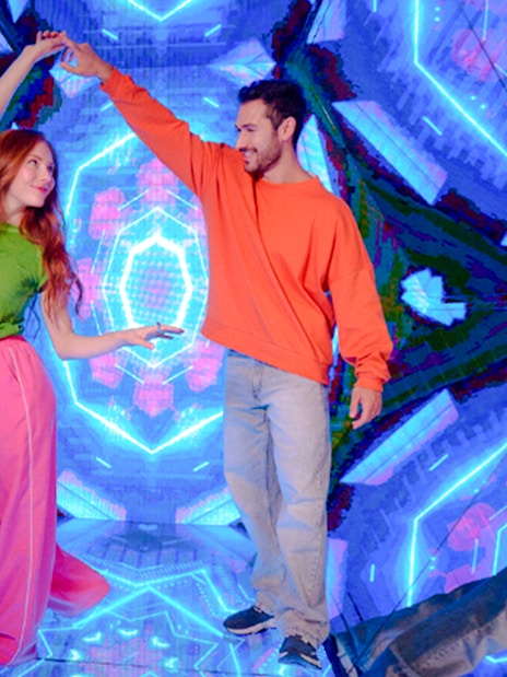 Guests enjoying interactive exhibit at Paradox Museum London with vibrant neon lights.