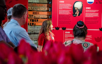 Tour guide explaining tulip history at Tulip Experience Amsterdam exhibit.