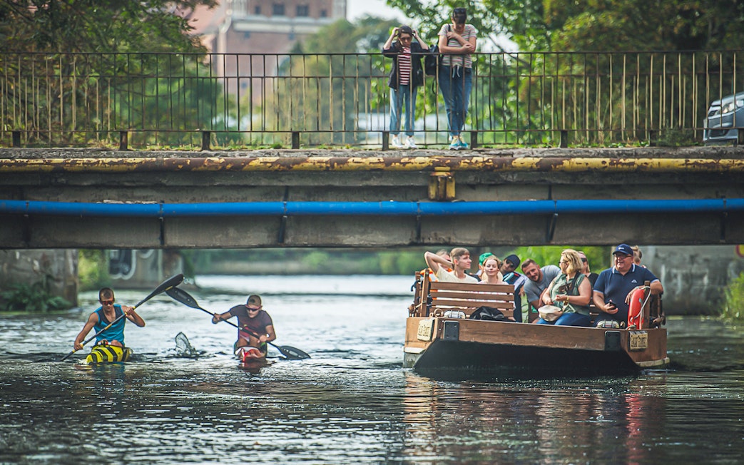 Guests enjoying a 1-hour cruise on a historical Galar boat under a bridge.