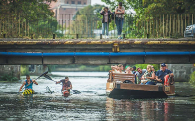Guests enjoying a 1-hour cruise on a historical Galar boat under a bridge.