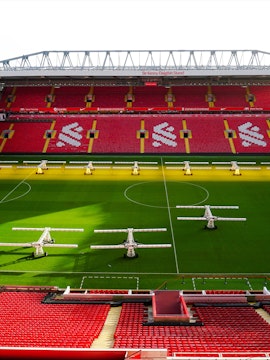 Liverpool FC stadium aerial view, showcasing the iconic red exterior and surrounding cityscape.