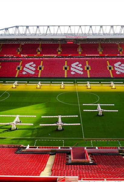 Liverpool FC stadium aerial view, showcasing the iconic red exterior and surrounding cityscape.