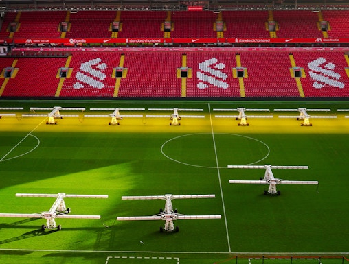 Liverpool FC stadium aerial view, showcasing the iconic red exterior and surrounding cityscape.