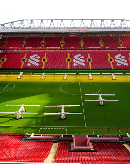 Liverpool FC stadium aerial view, showcasing the iconic red exterior and surrounding cityscape.