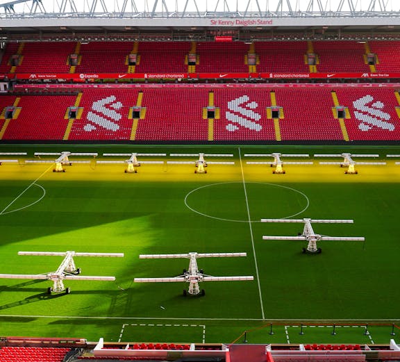 Liverpool FC stadium aerial view, showcasing the iconic red exterior and surrounding cityscape.