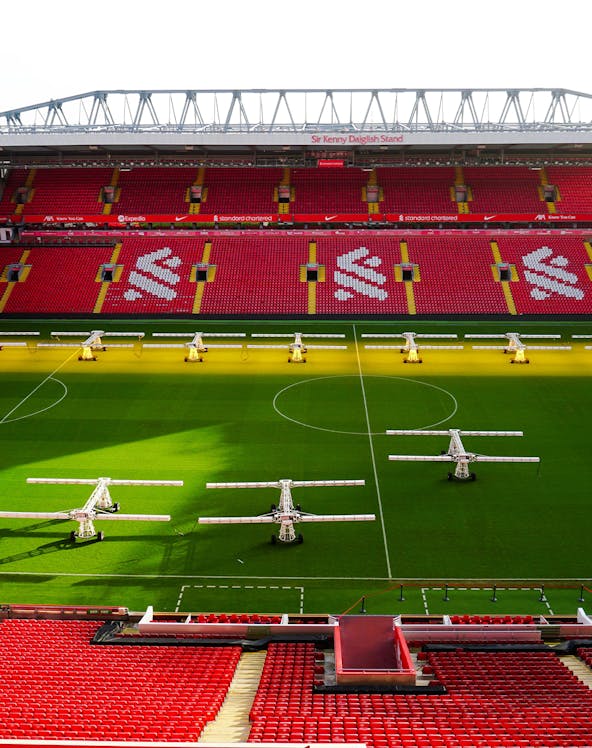 Liverpool FC stadium aerial view, showcasing the iconic red exterior and surrounding cityscape.