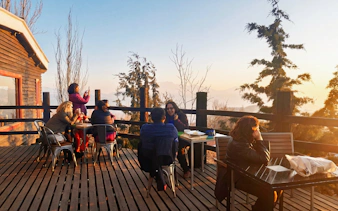 Outdoor terrace with people enjoying views of the Andes Mountains in Chile.
