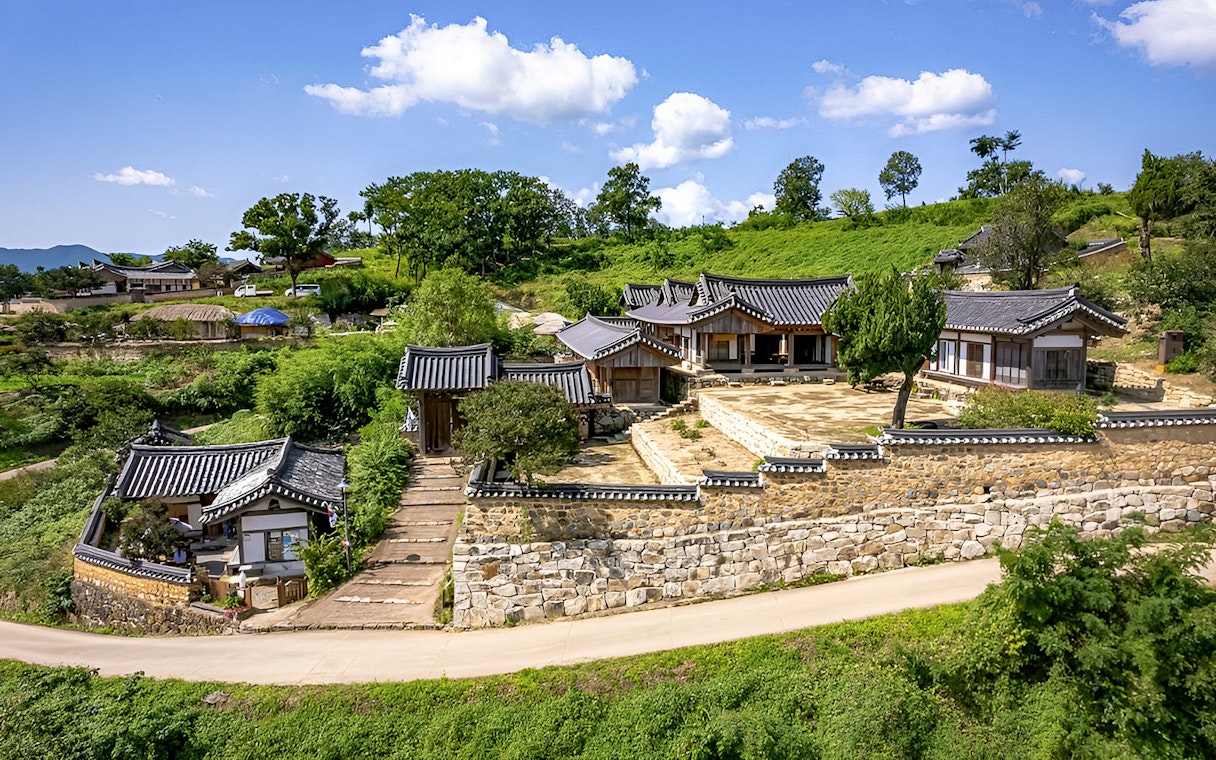 Traditional Korean houses in Gyeongju, surrounded by lush greenery, part of UNESCO World Heritage Tour.