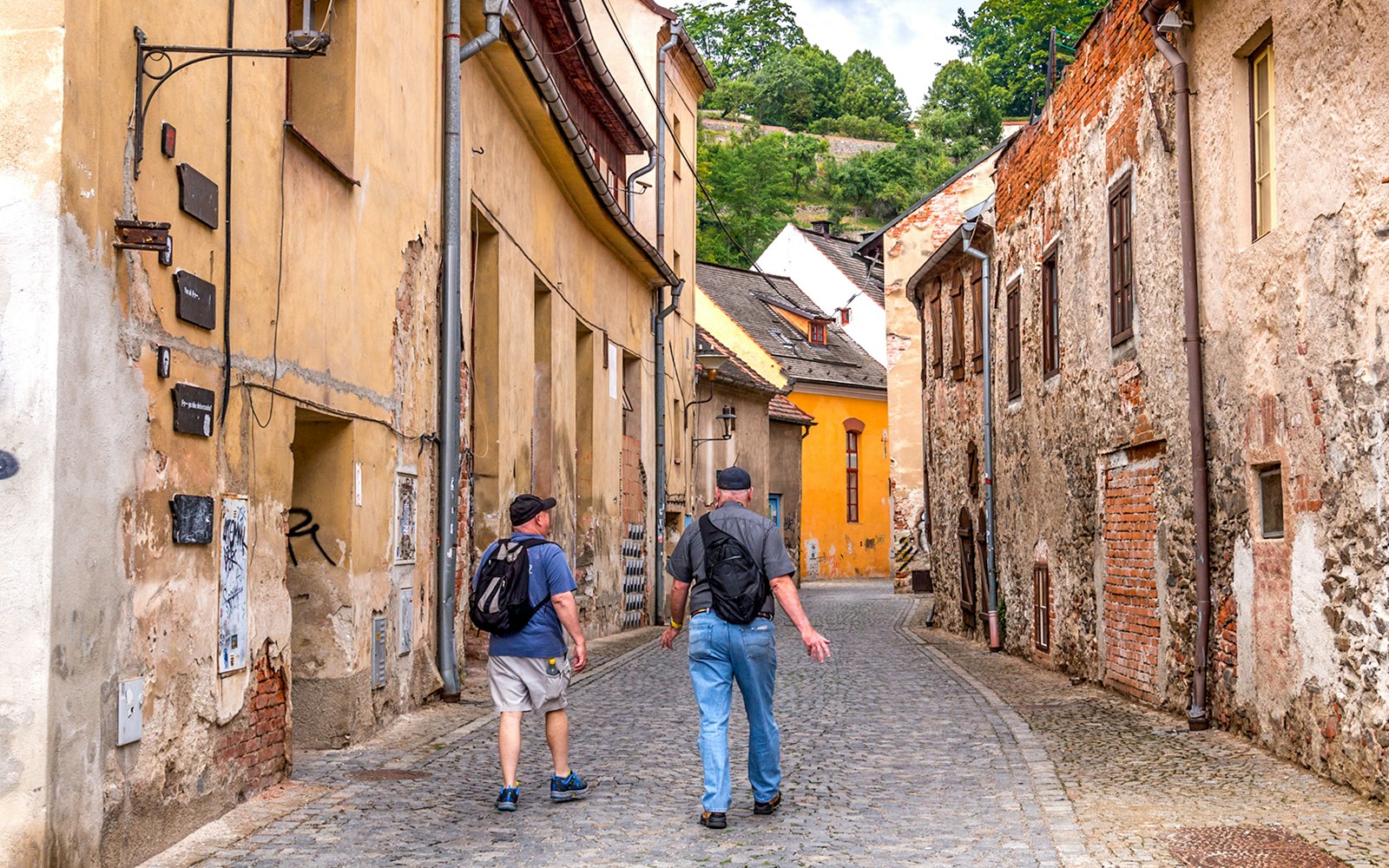 Tourists walking through a narrow cobblestone street in Cesky Krumlov.