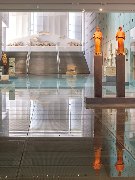 Acropolis Museum interior with ancient statues and artifacts on display.