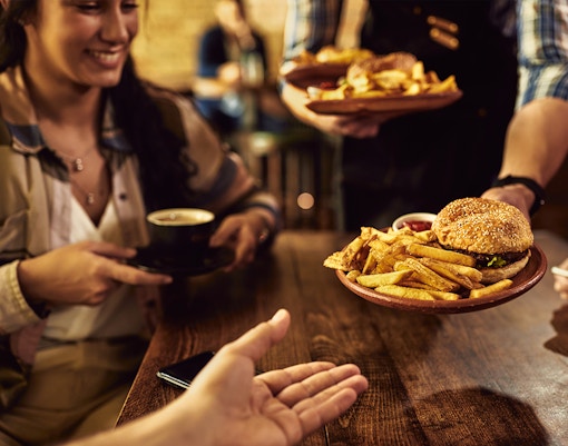 Group enjoying burgers and fries at a cozy restaurant.
