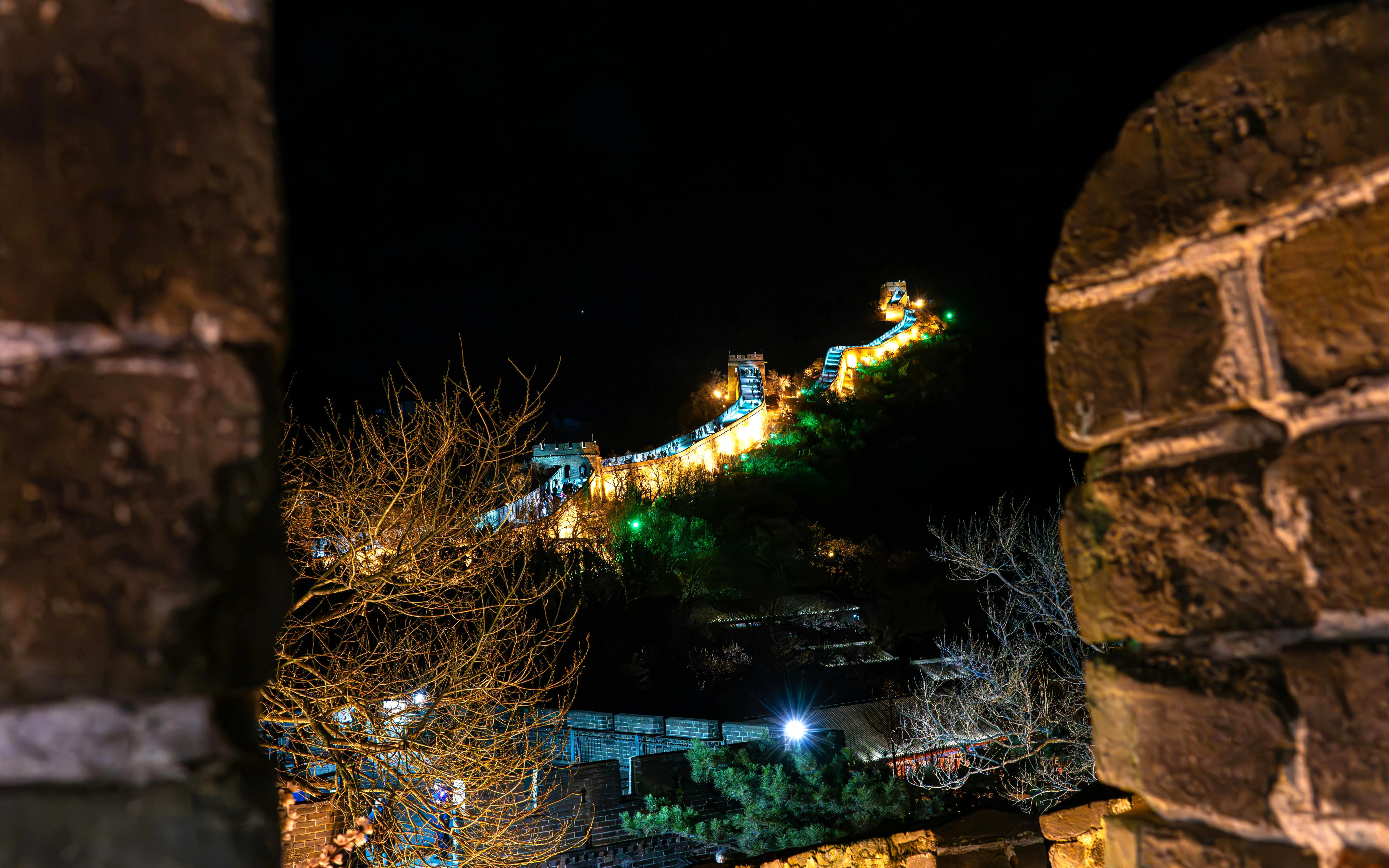 Badaling Great Wall illuminated at night, Beijing, viewed through stone archway.