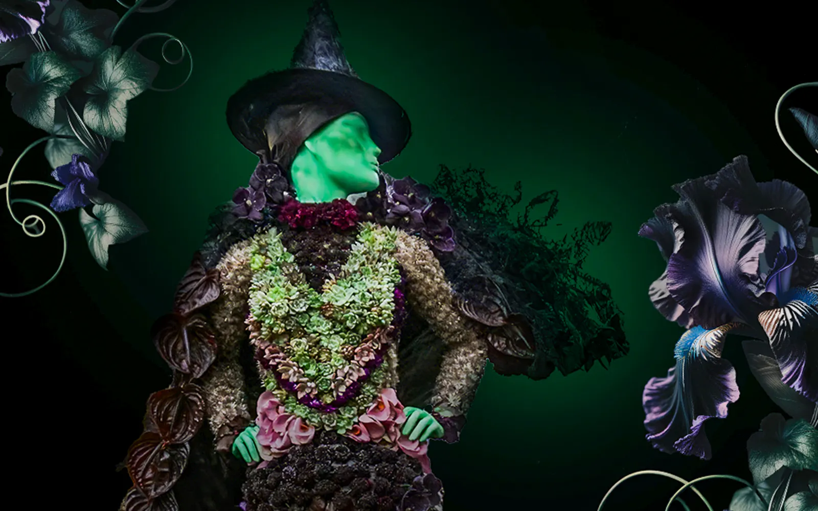Green-skinned figure in elaborate floral costume with a witch hat, surrounded by dark flowers.