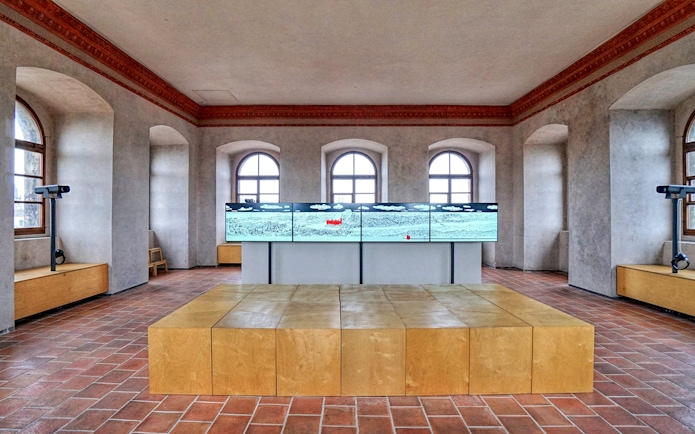 Interior of The New Mill Water Tower in Prague with digital display and arched windows.