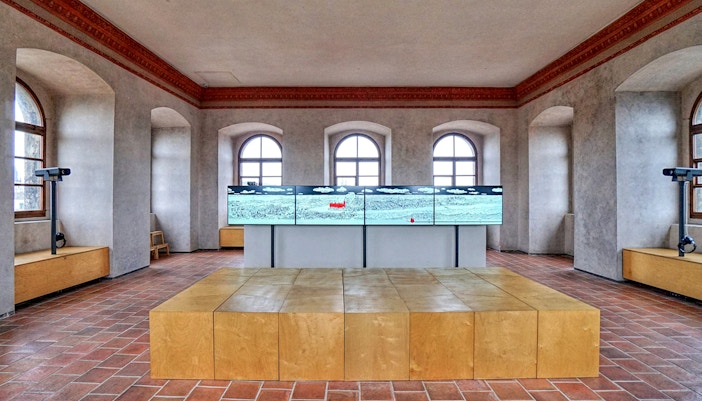 Interior of The New Mill Water Tower in Prague with digital display and arched windows.