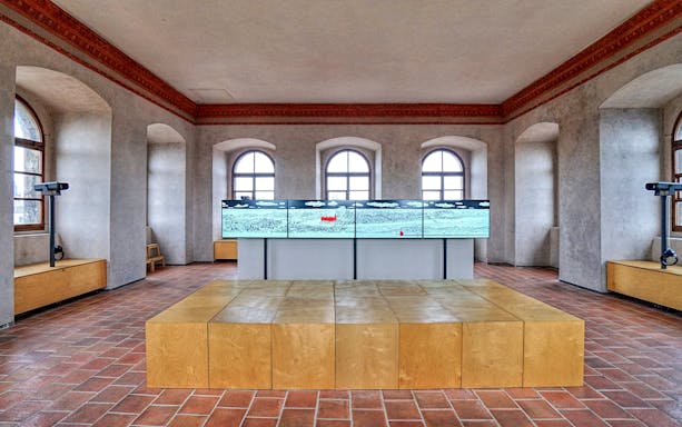Interior of The New Mill Water Tower in Prague with digital display and arched windows.