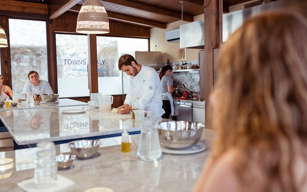Chef kneading dough during a cooking class in Palermo kitchen.