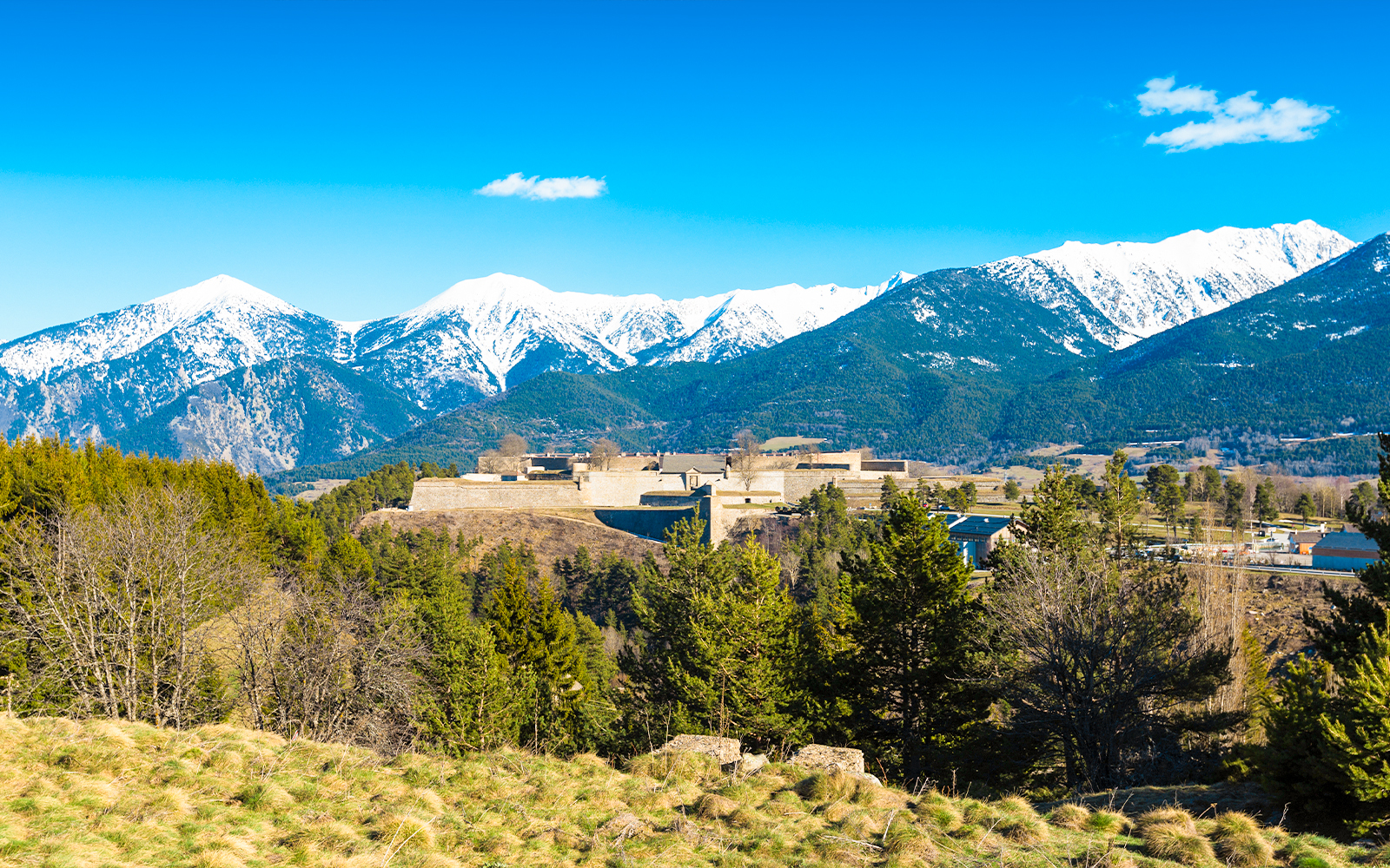 Fortification de Mont-Louis with snow-capped mountains in the background.
