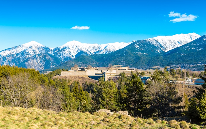Fortification de Mont-Louis with snow-capped mountains in the background.