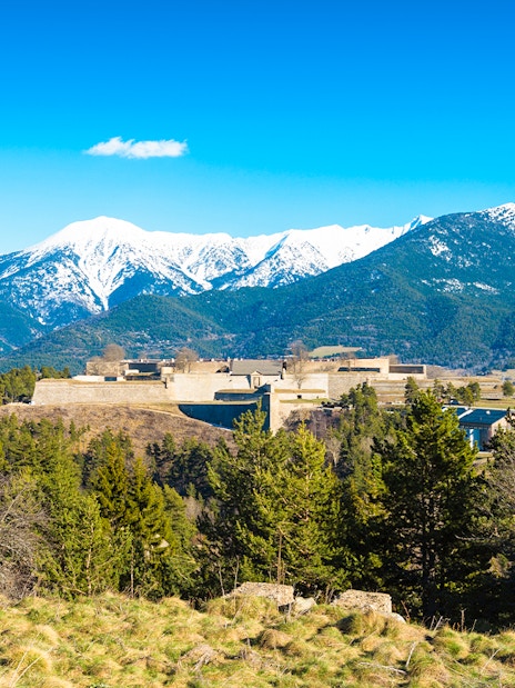 Fortification de Mont-Louis with snow-capped mountains in the background.