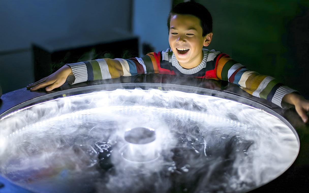Child exploring a fog exhibit at the Exploratorium in San Francisco.