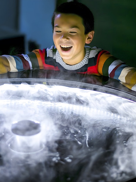 Child exploring a fog exhibit at the Exploratorium in San Francisco.