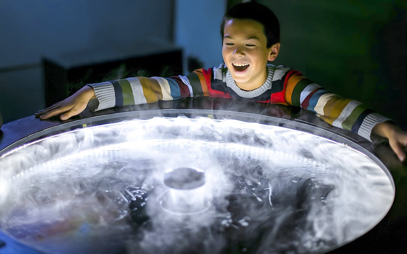 Child exploring a fog exhibit at the Exploratorium in San Francisco.