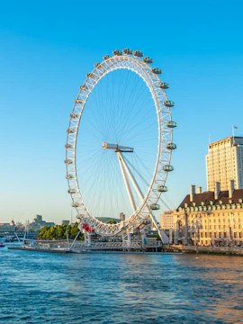 London Eye overlooking the Thames River on a sunny day.