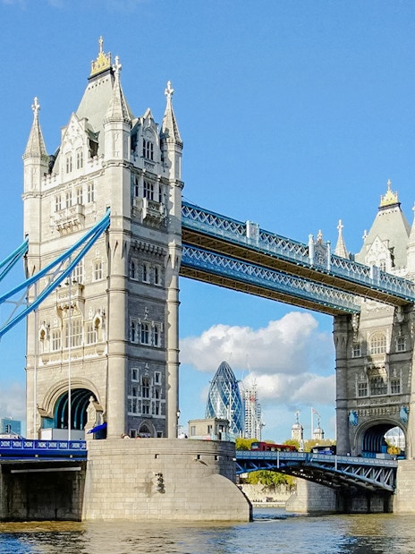 Tower Bridge spanning the River Thames in London, with blue sky background.