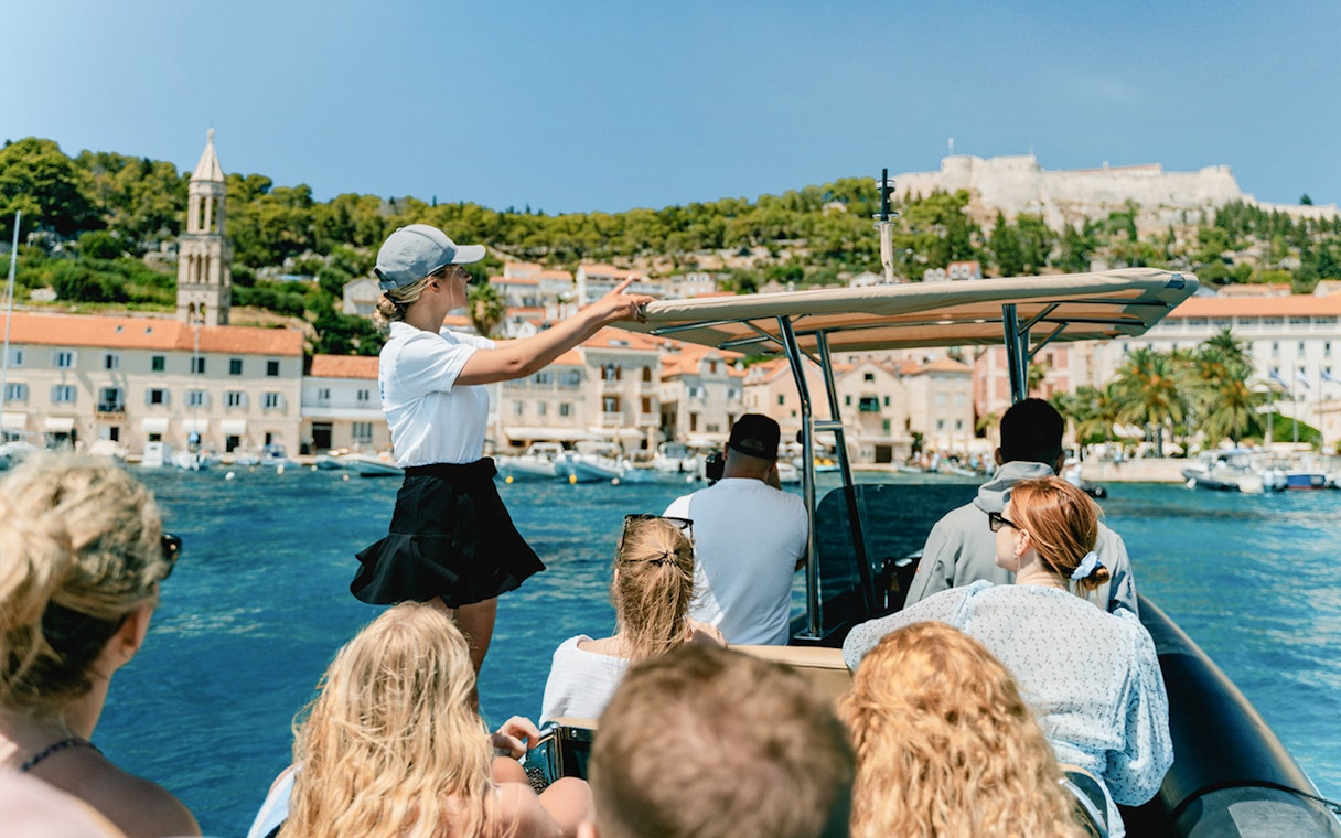 Guests on a speedboat tour with an instructor near a coastal town.