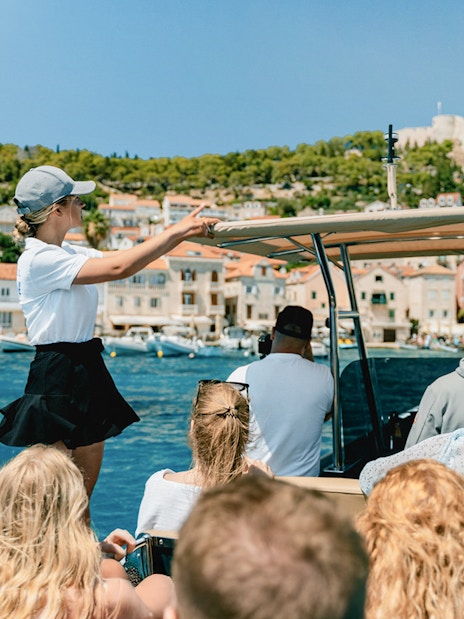 Guests on a speedboat tour with an instructor near a coastal town.