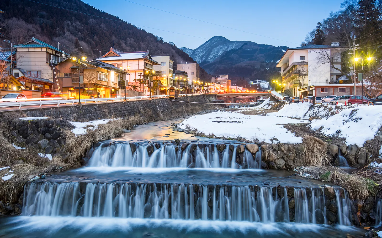 Shibu Onsen town with illuminated buildings and snowy landscape in Yamanouchi, Japan.