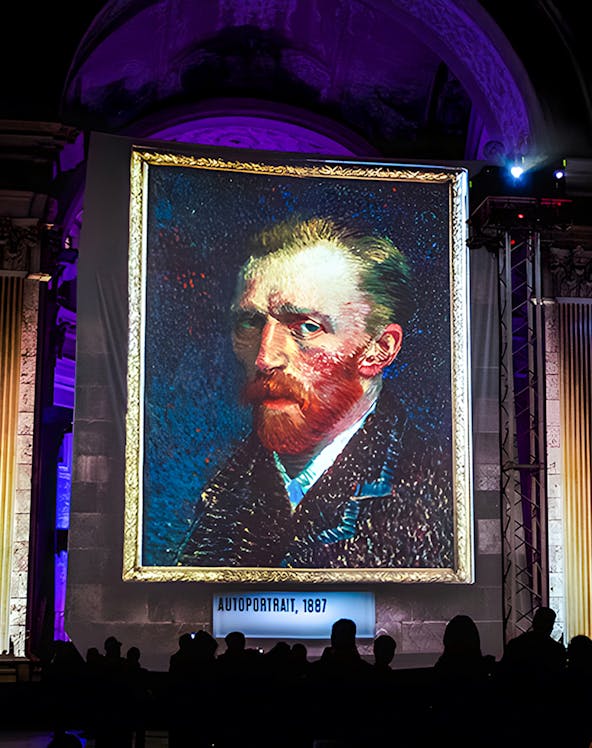 Van Gogh self-portrait at London exhibition with guests viewing.