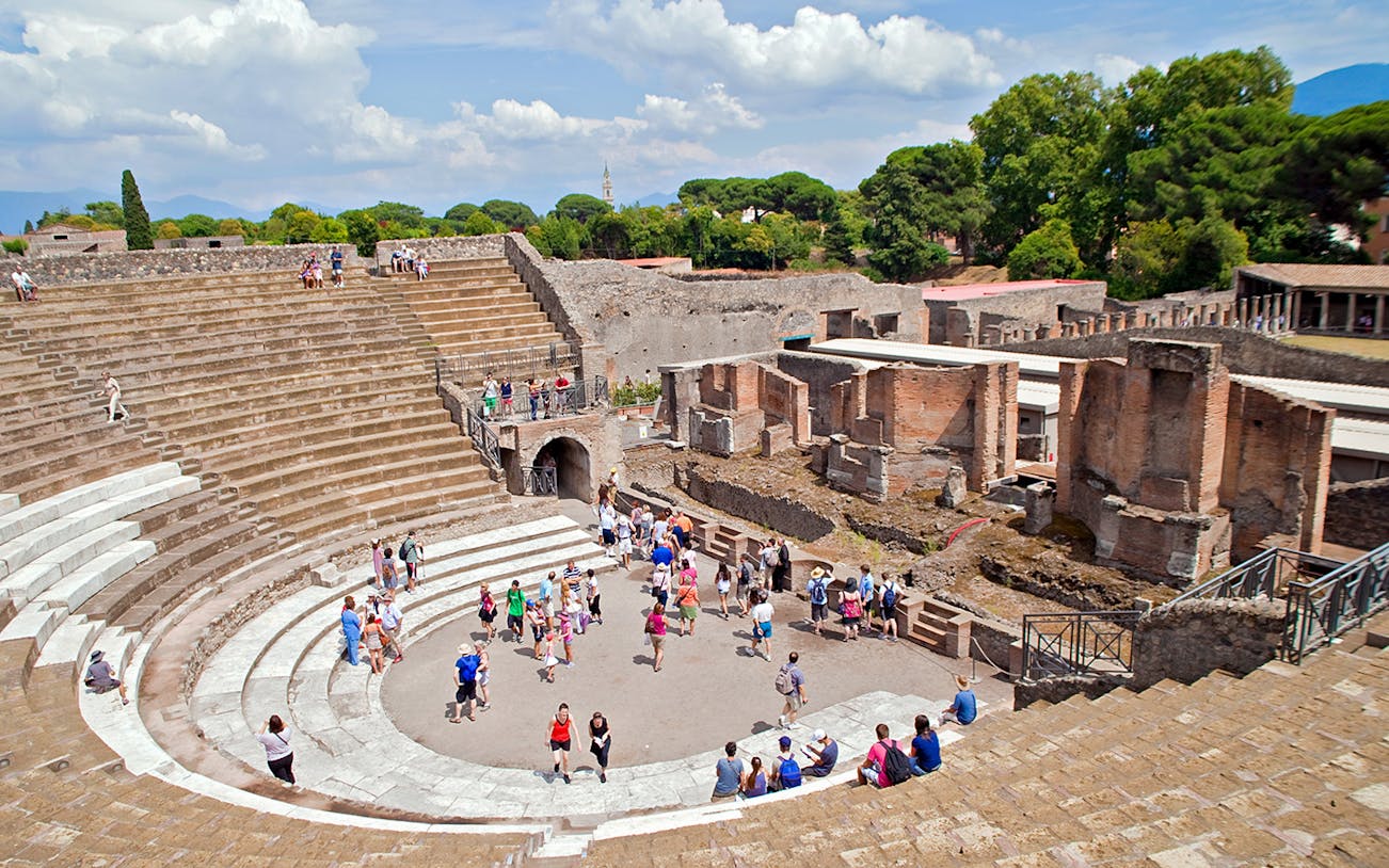 Tour group exploring the ancient amphitheater in Pompeii, Italy.