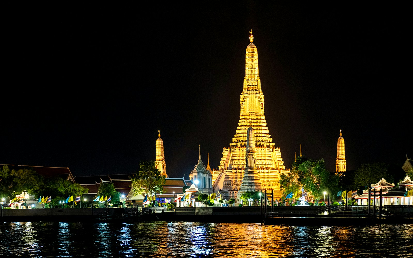 Wat Pho illuminated at night, viewed from the Bangkok river.