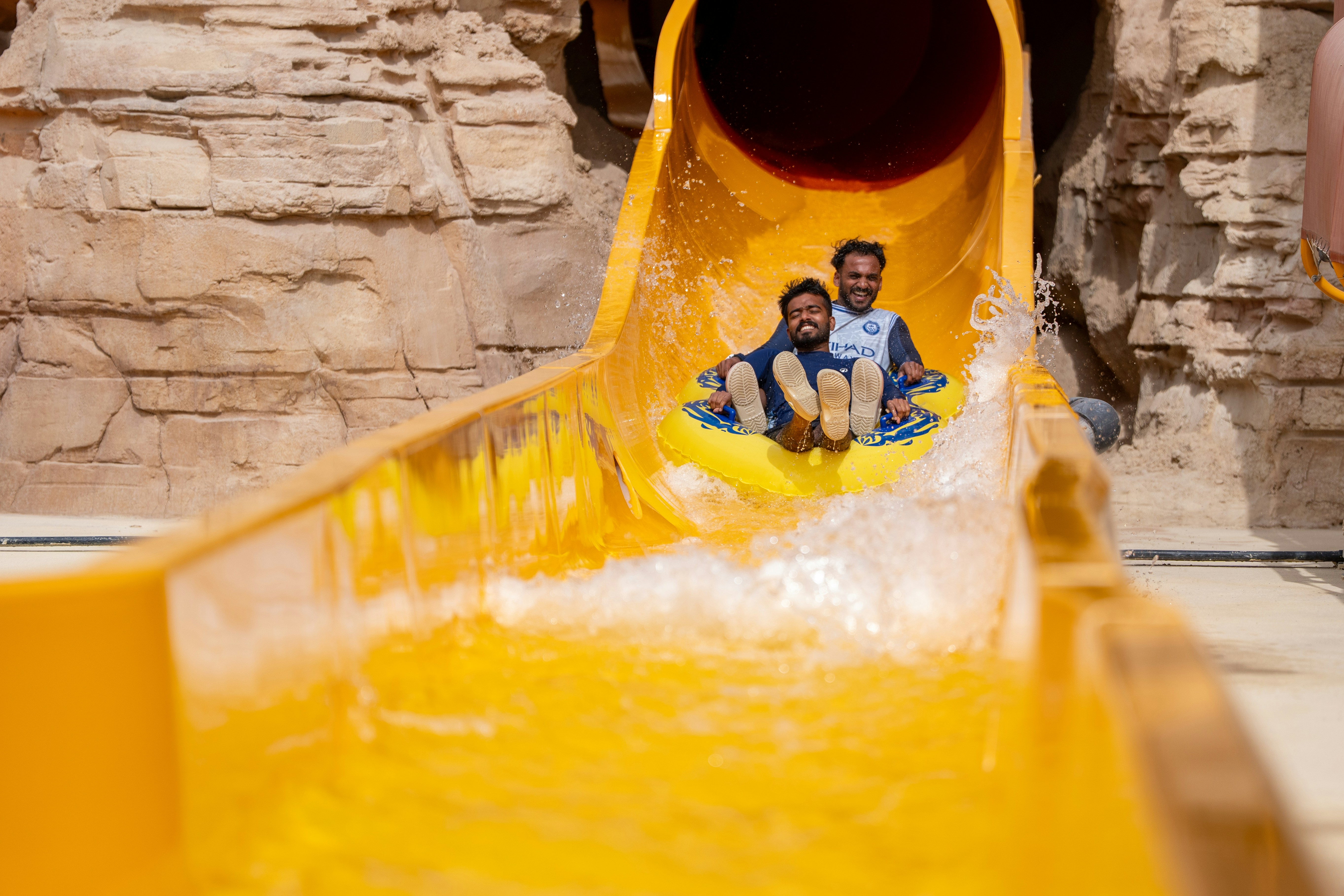 Two people enjoying a water slide at Aquarabia Water Theme Park, Qiddiya City, Saudi Arabia.