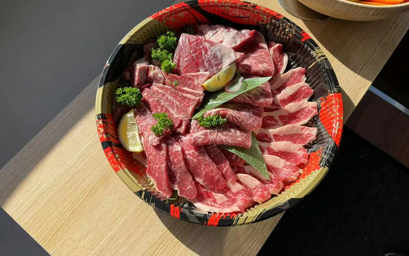 Sliced marbled beef with lemon and parsley garnish on a platter, Hobart Private Yacht Charter.