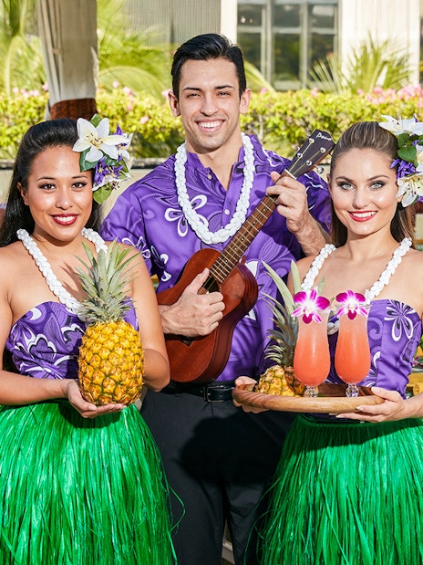 Staff with welcome drinks and pineapples before the Rock-A-Hula Show in Hawaii.