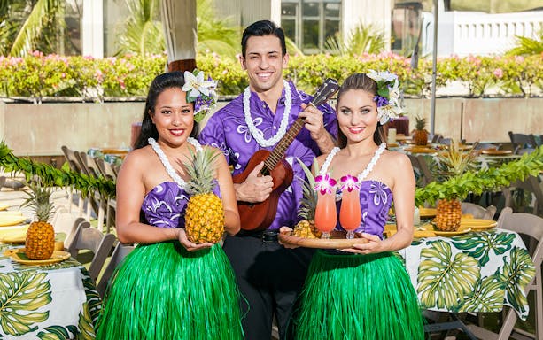 Staff with welcome drinks and pineapples before the Rock-A-Hula Show in Hawaii.