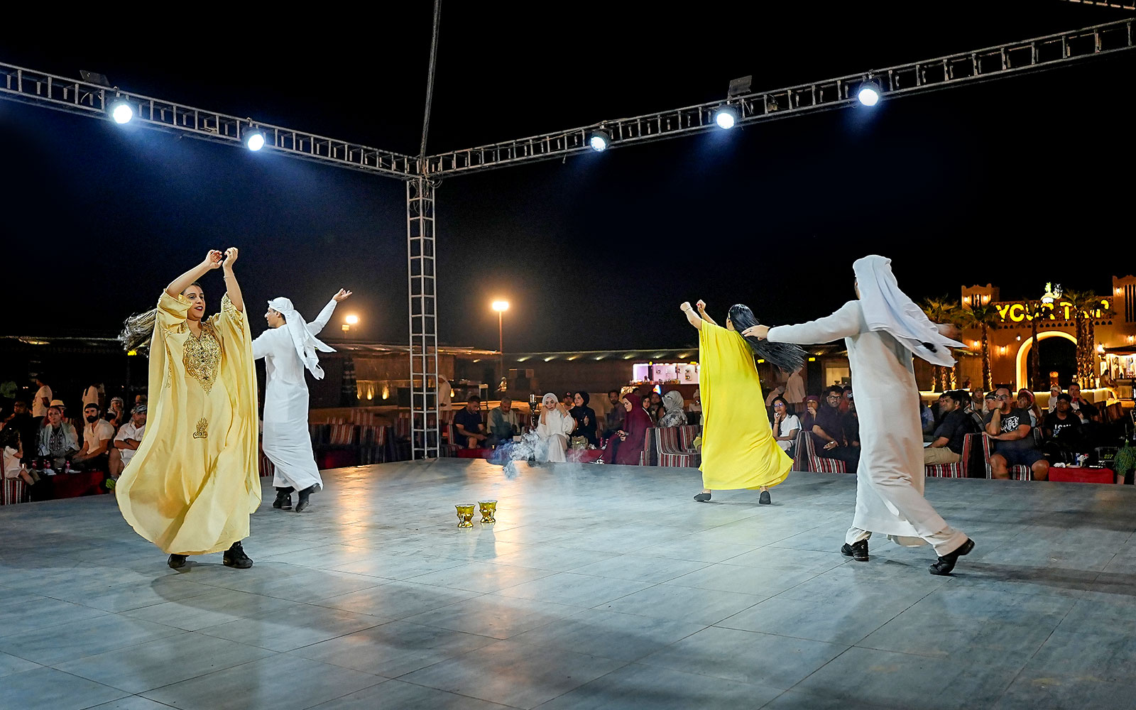 Evening desert safari with traditional dance performance under lights.
