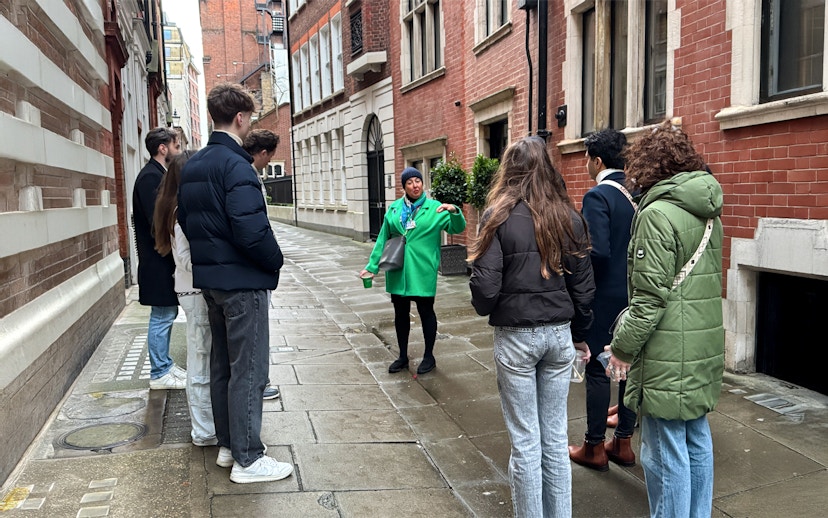 Tour guide leading a group through a historic London street near Westminster Abbey.