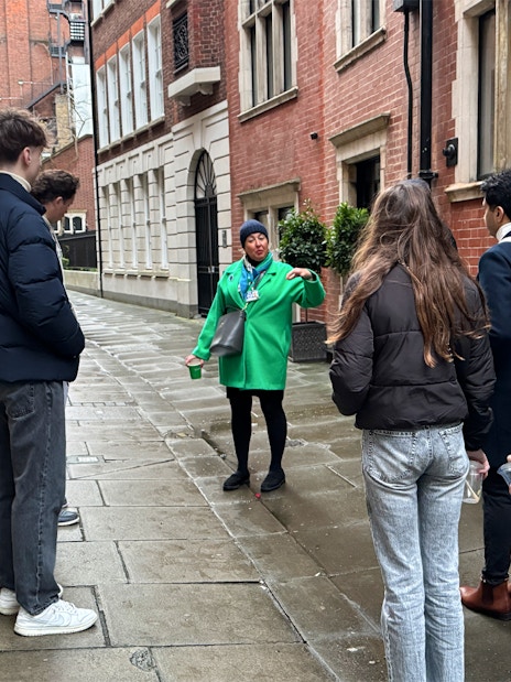 Tour guide leading a group through a historic London street near Westminster Abbey.