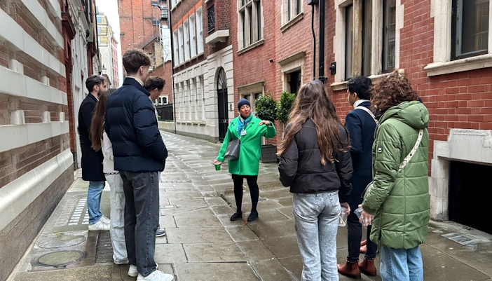 Tour guide leading a group through a historic London street near Westminster Abbey.