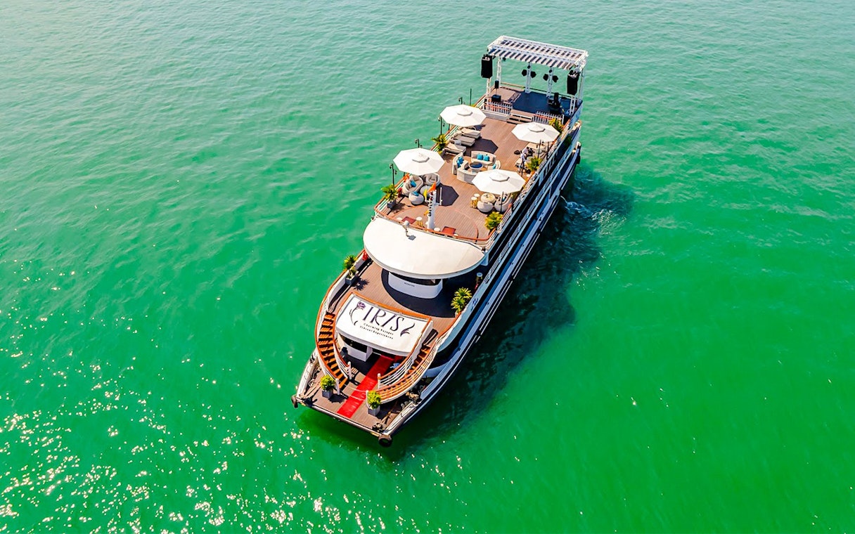 Luxury cruise ship Iris on Ha Long Bay, Vietnam, with sun decks and seating areas.